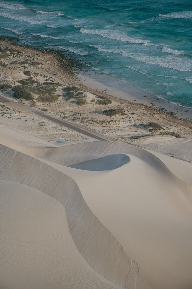 Textures of shoreline sand and ridges. Intricate sand formations near water with shadow and muted colors