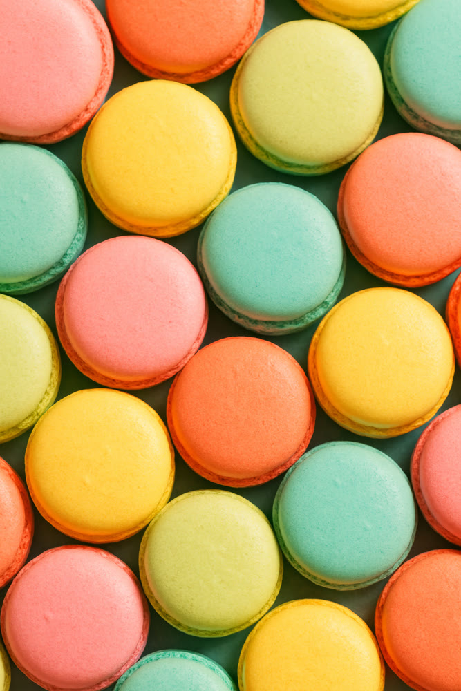 Assorted pastel macarons meticulously organized in grid to enhance festive and promotional visuals